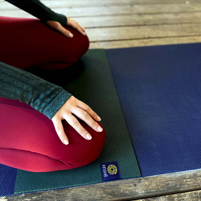 A woman kneels on a MiniMat - mini yoga mat for knees & elbows
