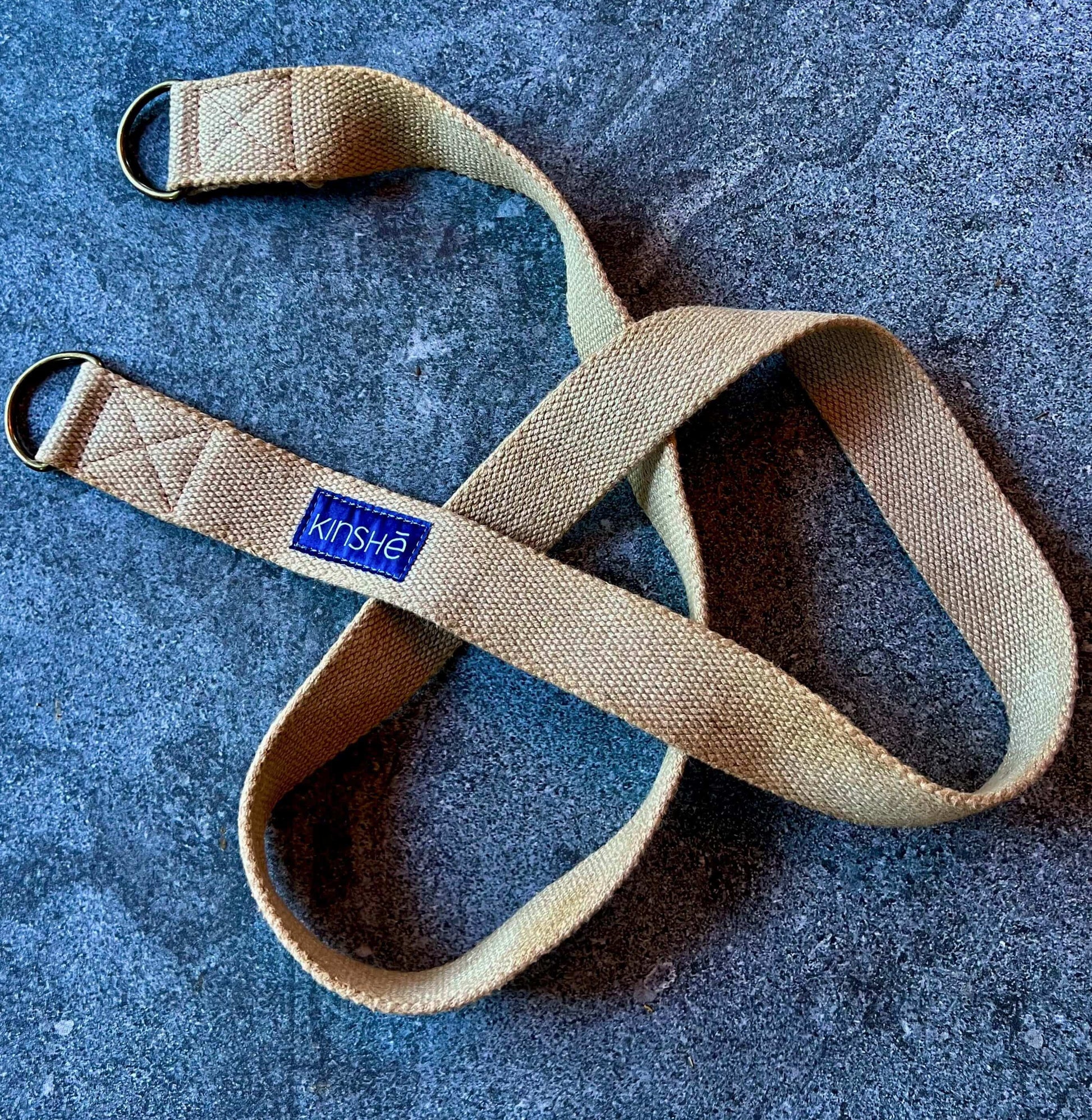 A 100 percent hemp Yoga Strap spirals on a tile of blue grey slate. 