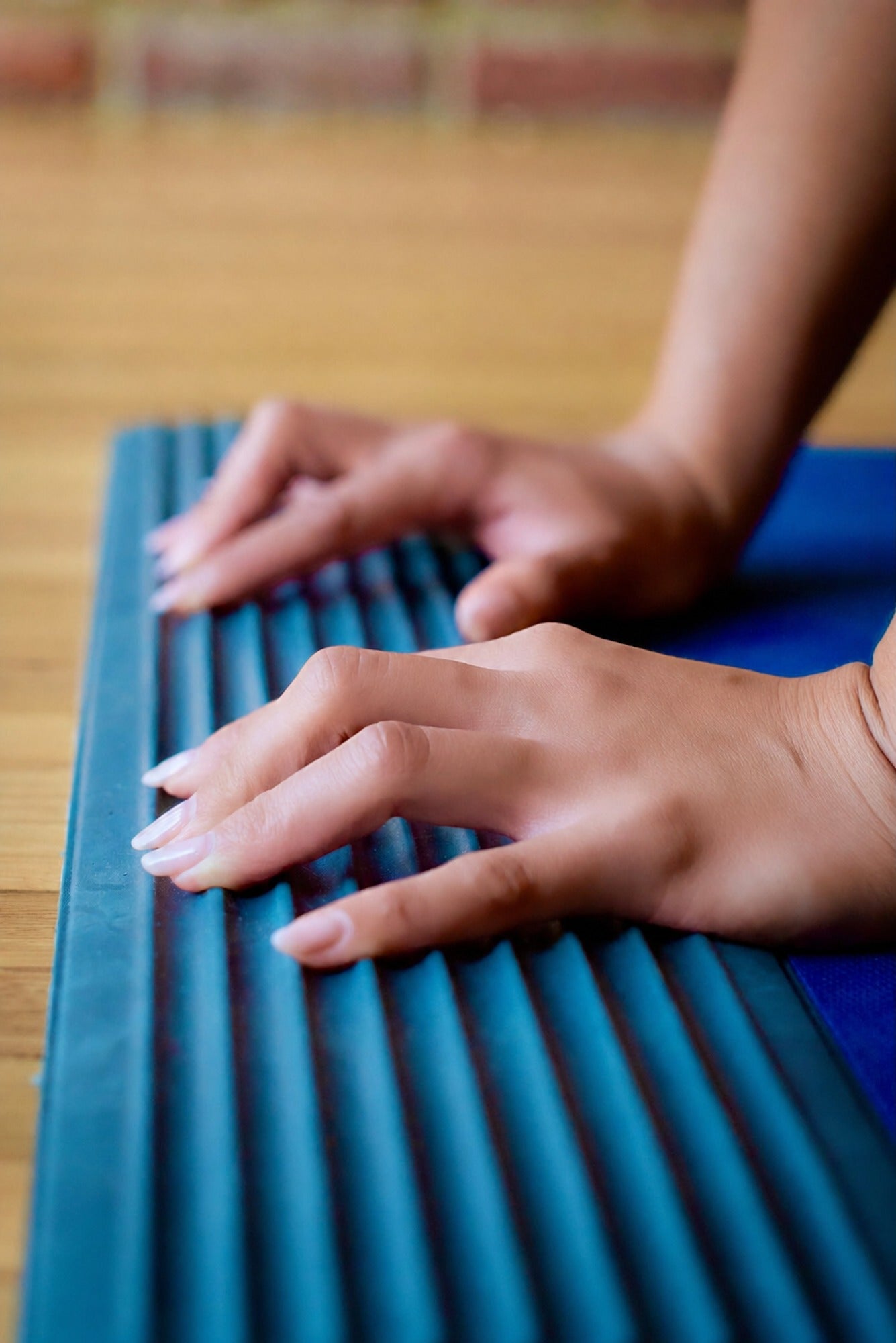 Hands on ridged yoga mat, smoothed skin retouch